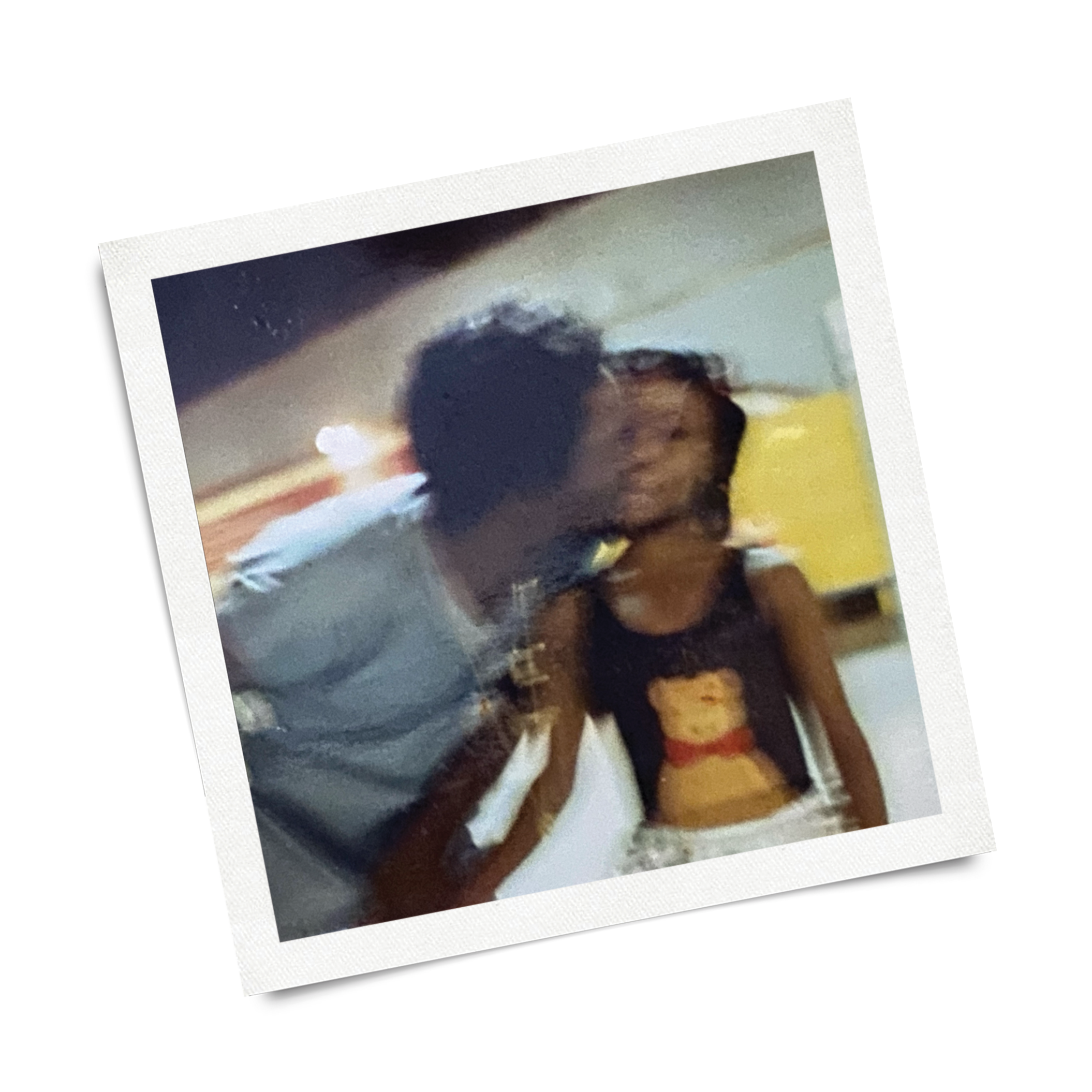 A printed photograph of a woman with curly hair, wearing a light-colored top.