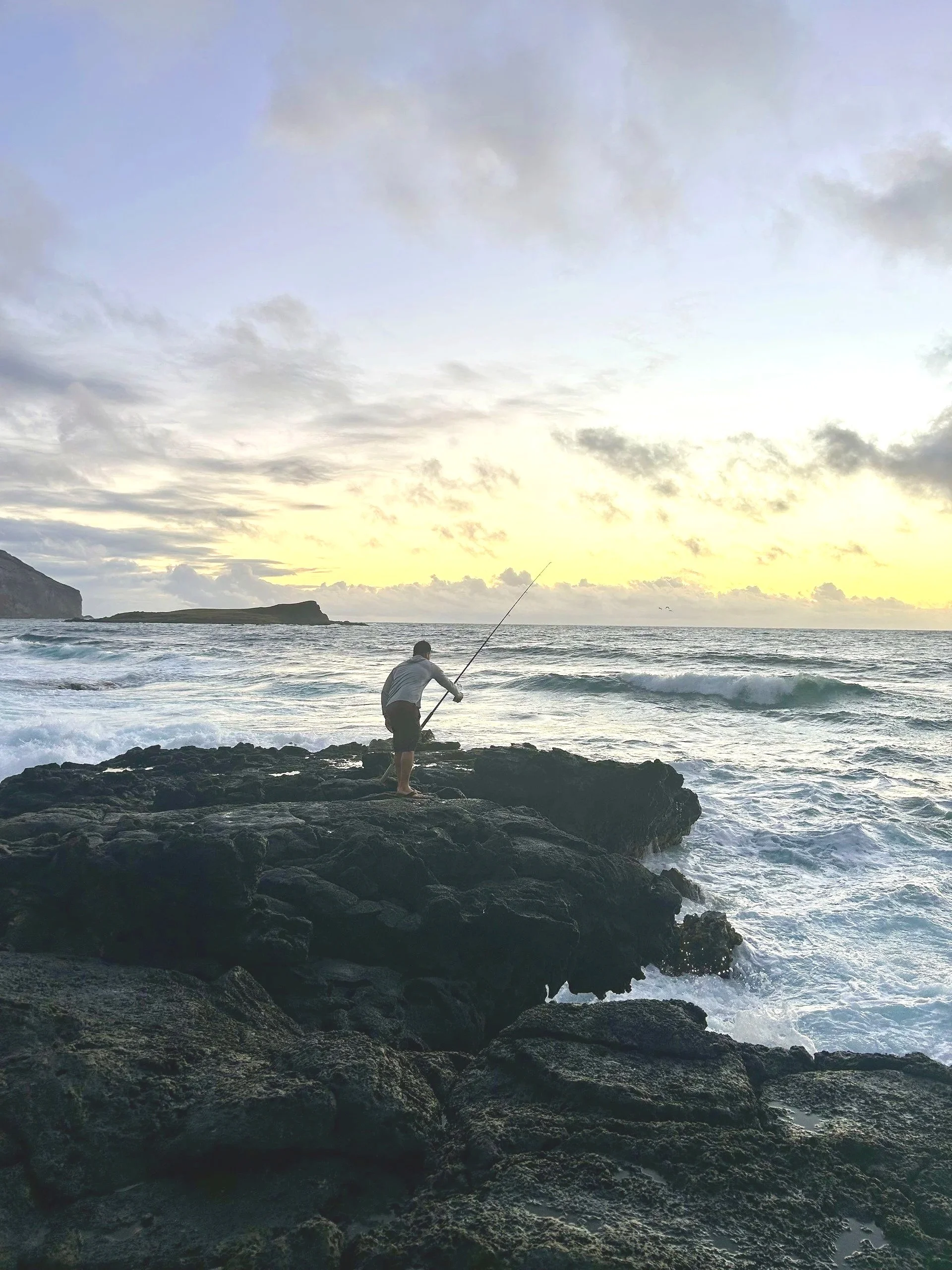 Oahu coastline with an angler fishing at sunrise