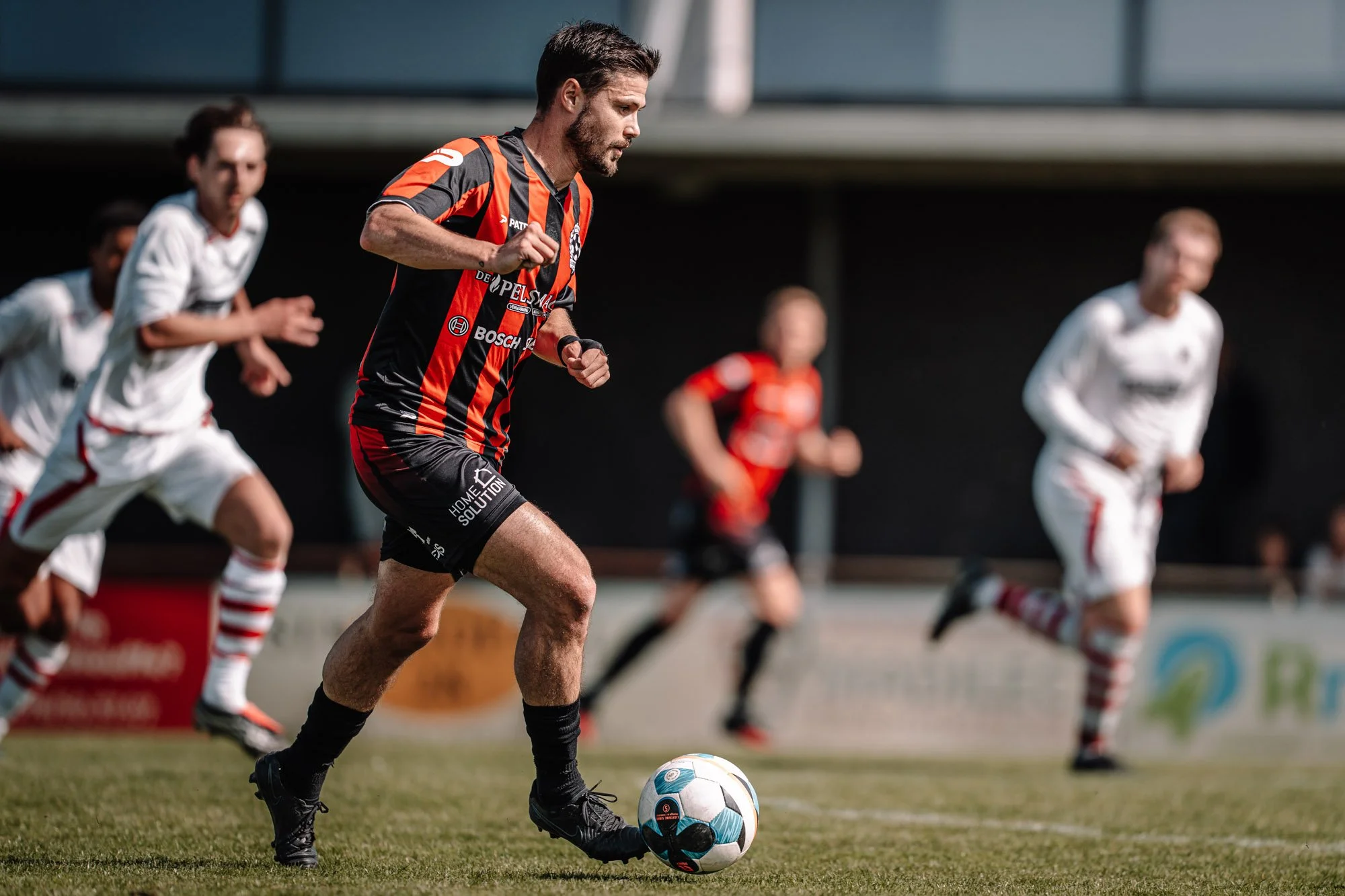 Een man in een sporttenue speelt voetbal en rijdt in een wedstrijd.