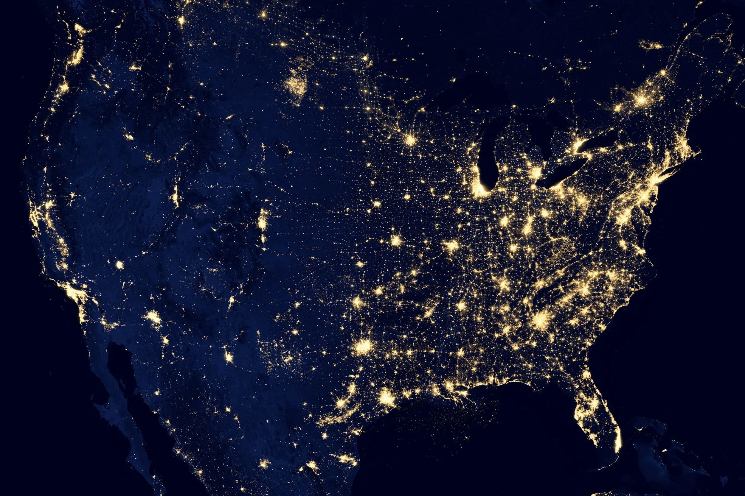 Mapa do continente americano à noite com luzes representando áreas urbanas e cidades.