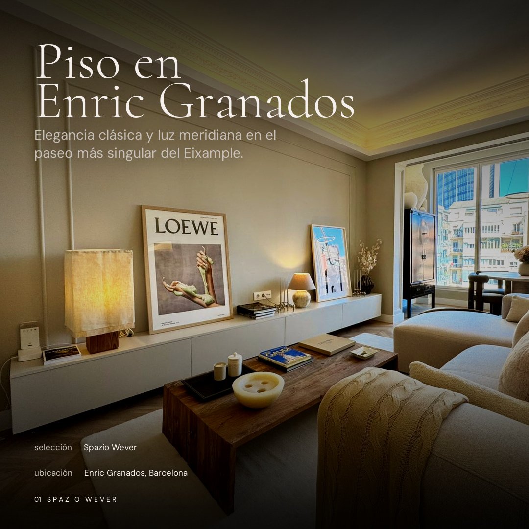 Sala de estar con sillones beige, mesa de madera, cuadros en la pared, lámparas y ventanas grandes con vista a edificios en Barcelona.