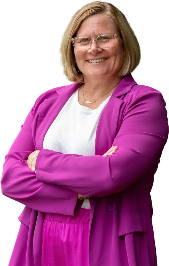 Jen Brooks in a bright pink blazer, arms crossed, smiling