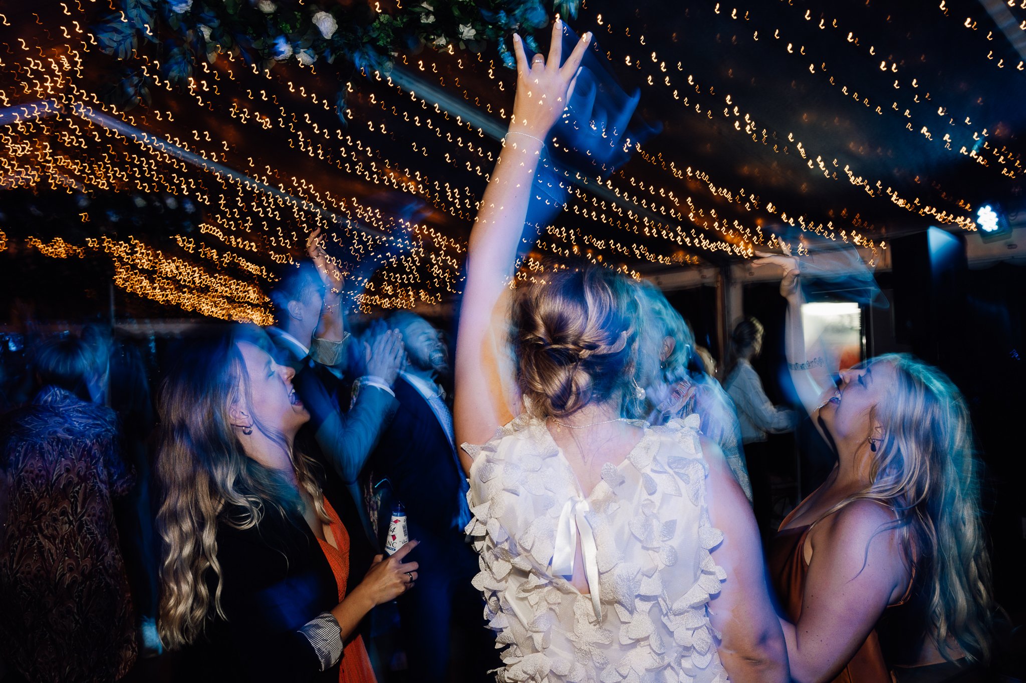 Folk danser og har det sjovt under julelys på et festligt arrangement.