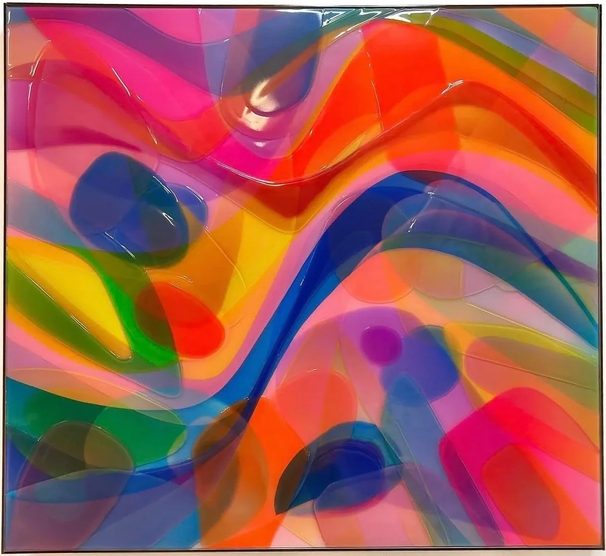 A vibrant, abstract colorful artwork featuring swirling shapes and overlapping translucent blobs in shades of pink, orange, yellow, green, blue, and purple.