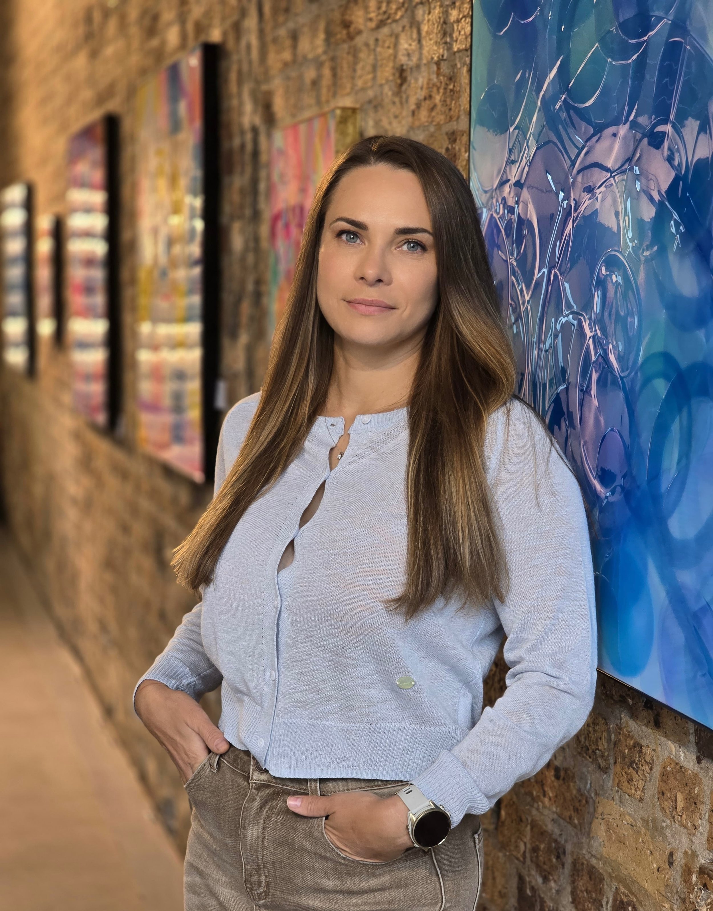 Portrait of contemporary artist Daria Baluta at Young Blood Africa during the exhibition What's the Matter.  Standing next to her large scale original artwork "Cerulean".