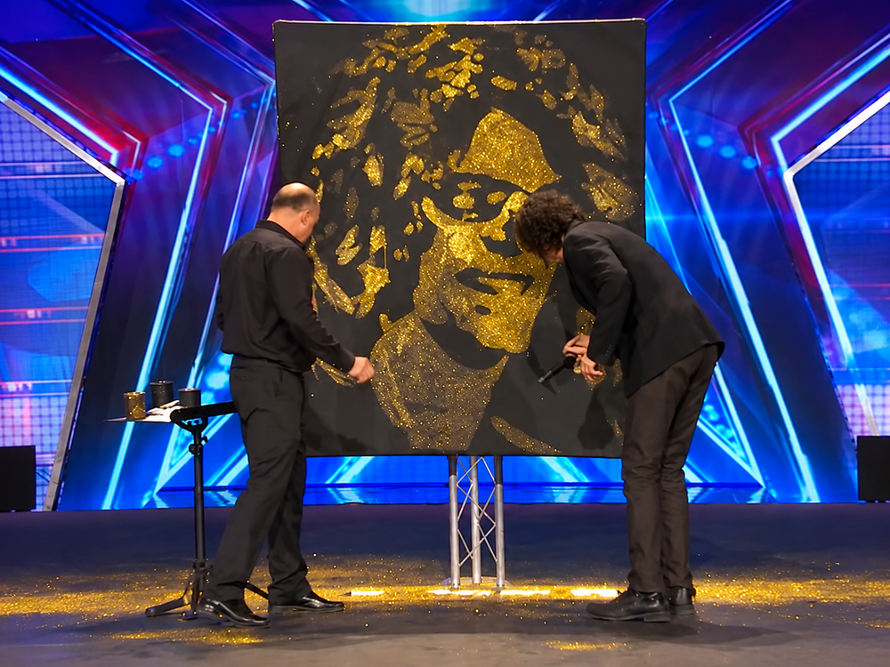 Robert Channing creating a gold glitter portrait on the America's Got Talent stage