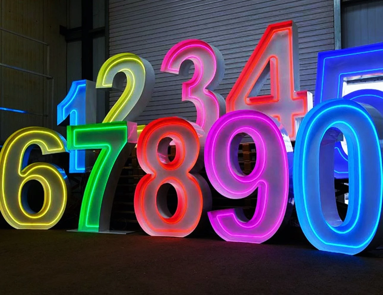 Colorful, illuminated numbers 1 through 0 in a display at night.