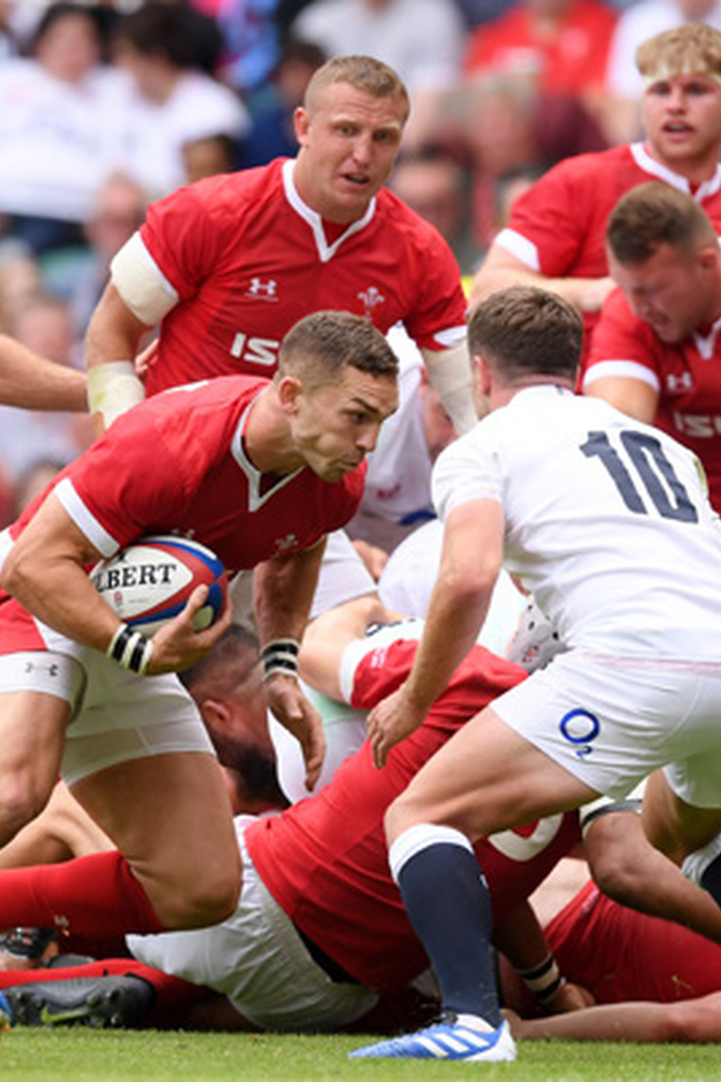 Rugby players in red and white uniforms competing for the ball during a match.
