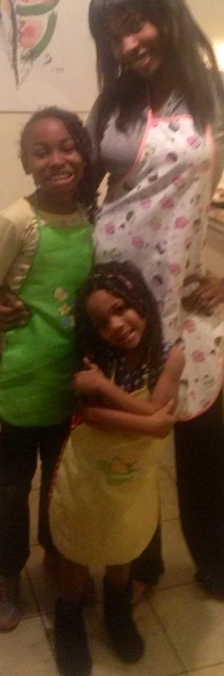 Kami Divine, cooking with a young Kaliyah and Jazmine.
