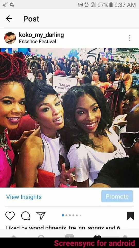 Group of people at the Essence Festival, with three women in the foreground smiling and posing for a selfie, crowd in background, colorful event environment.