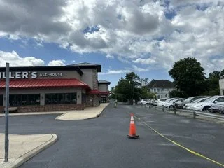 Freshly seal coated restaurant with a traffic cone and a yellow caution tape.