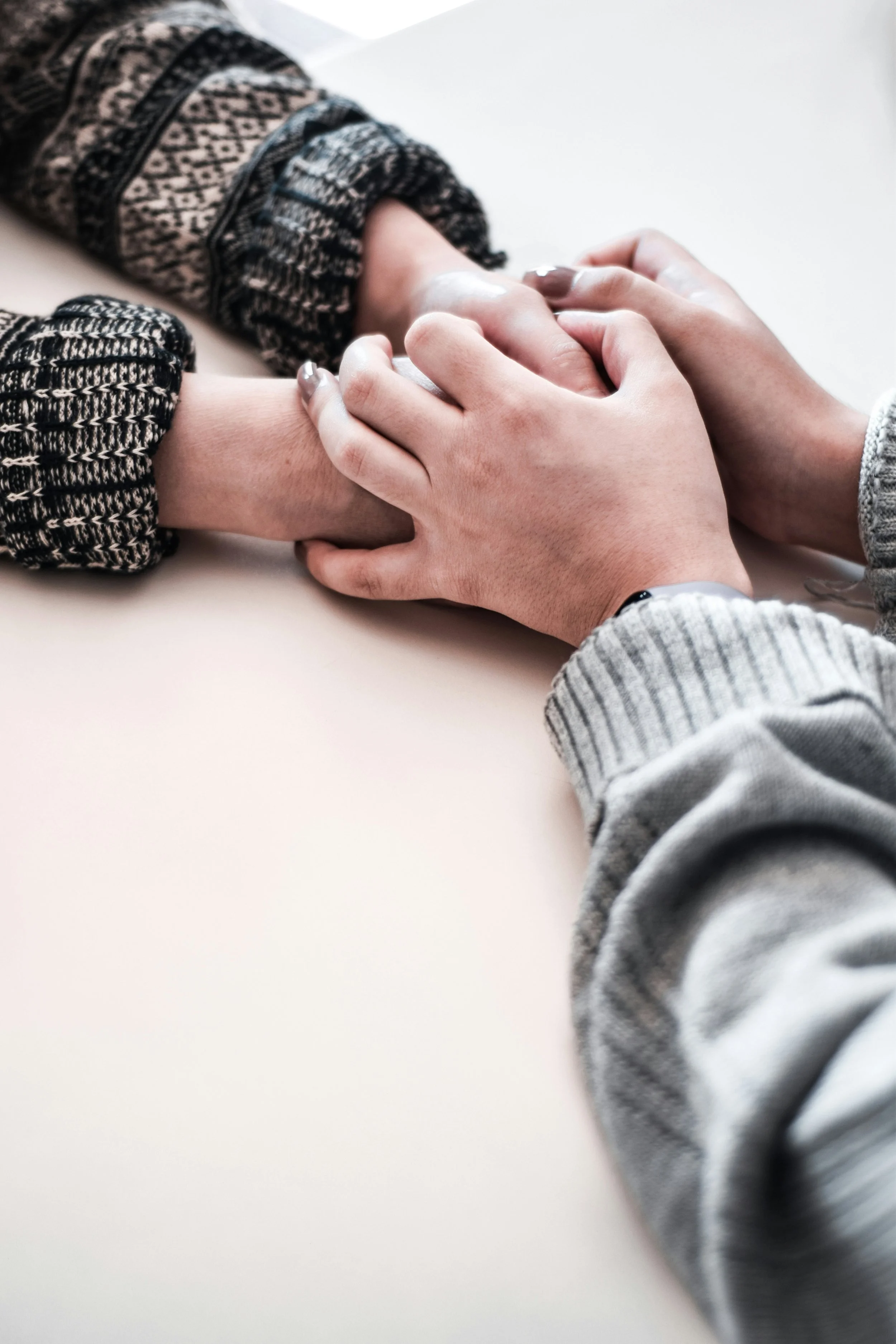 Hands resting together, representing support, compassion, and human connection while participating in a conjoint session.