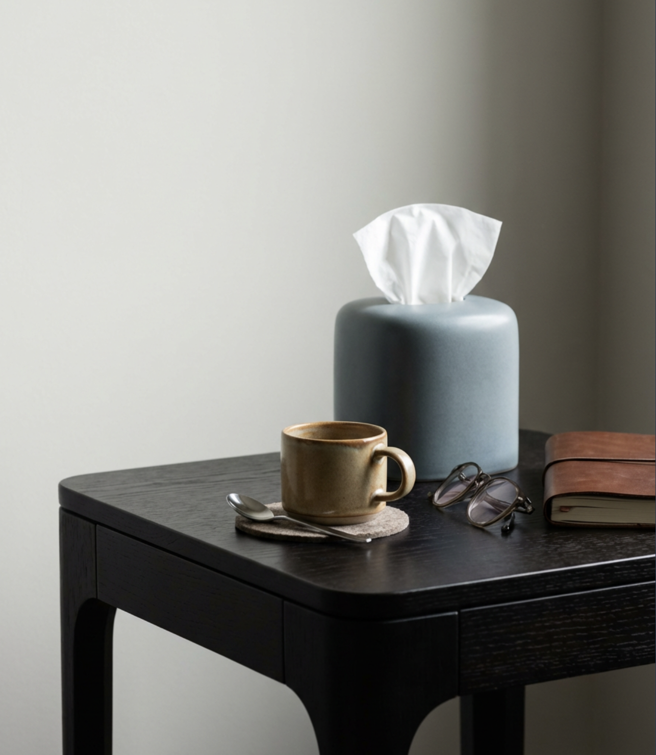 Comfortable therapy setting with a notebook, tissues, and coffee, representing a warm and welcoming environment.