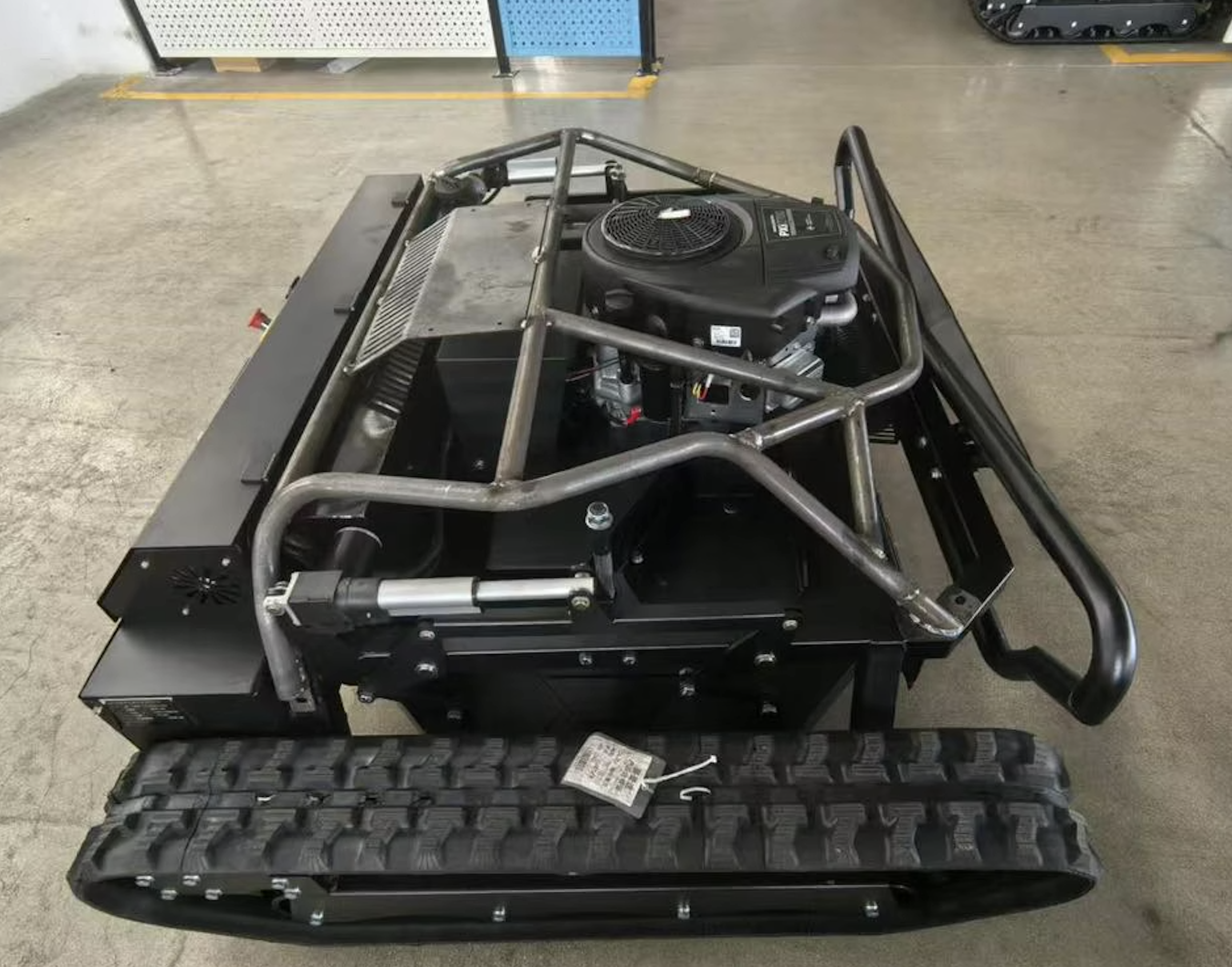 Side view of a portable generator with a metal frame, engine, and wheels in a workshop or garage.