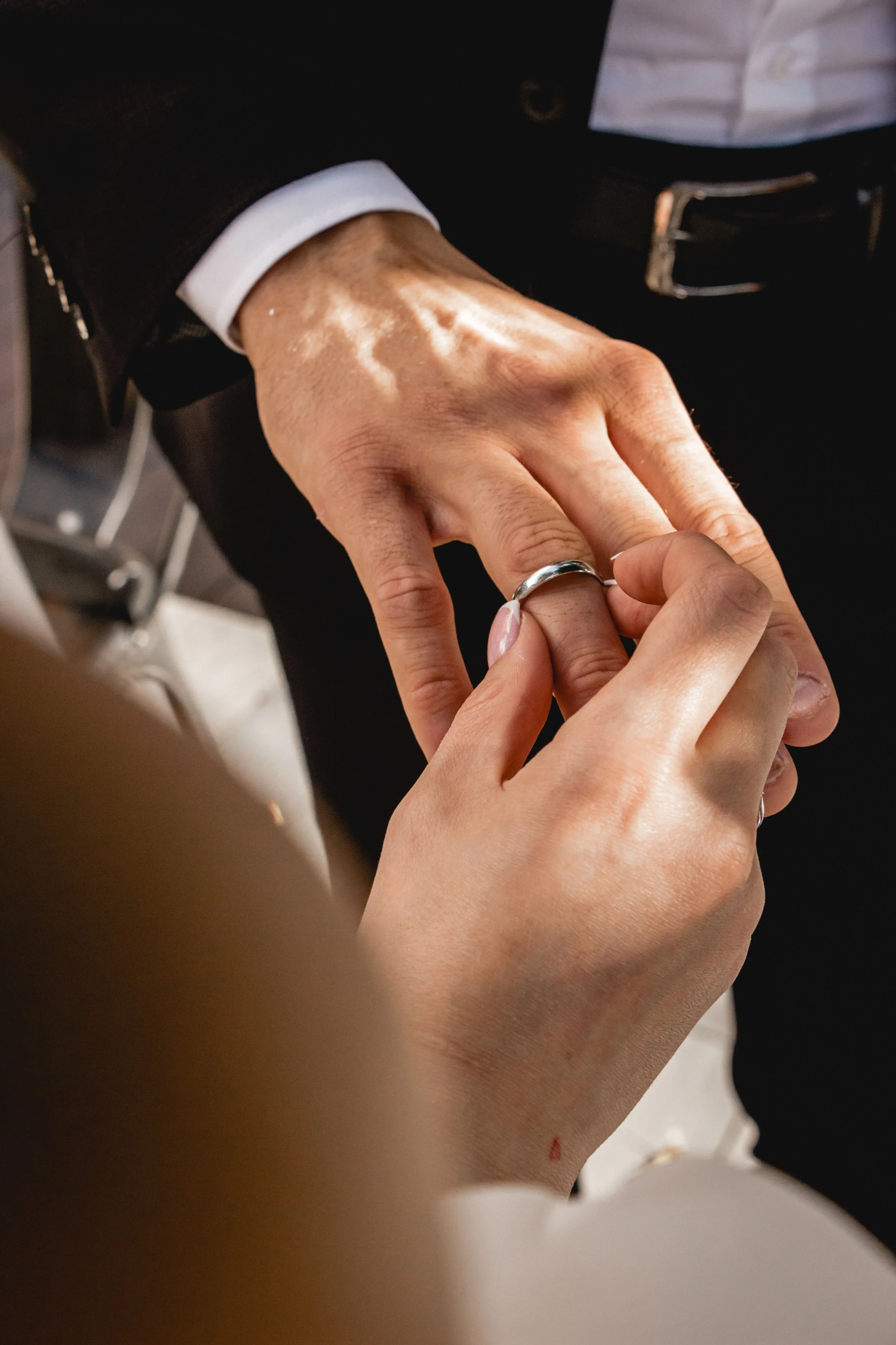 A person placing a ring on a woman's finger.