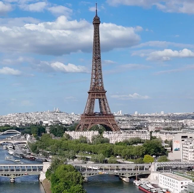 Eiffel Tower, Paris cityscape, and cloud-filled sky during day, representing consulting expertise in culture and community.