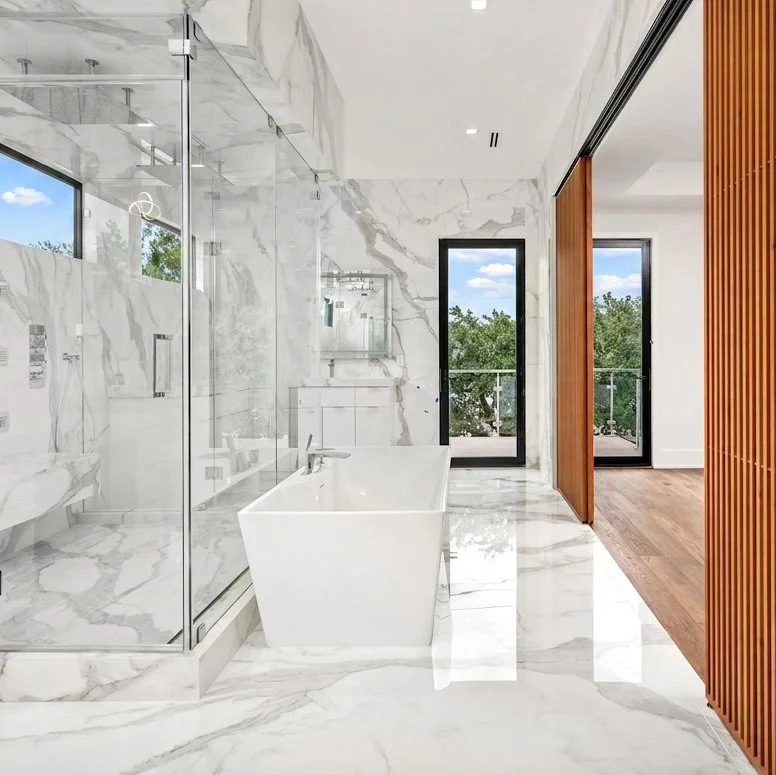Luxury bathroom with marble floors and walls, and sky-view windows, symbolizing style and home consulting expertise.