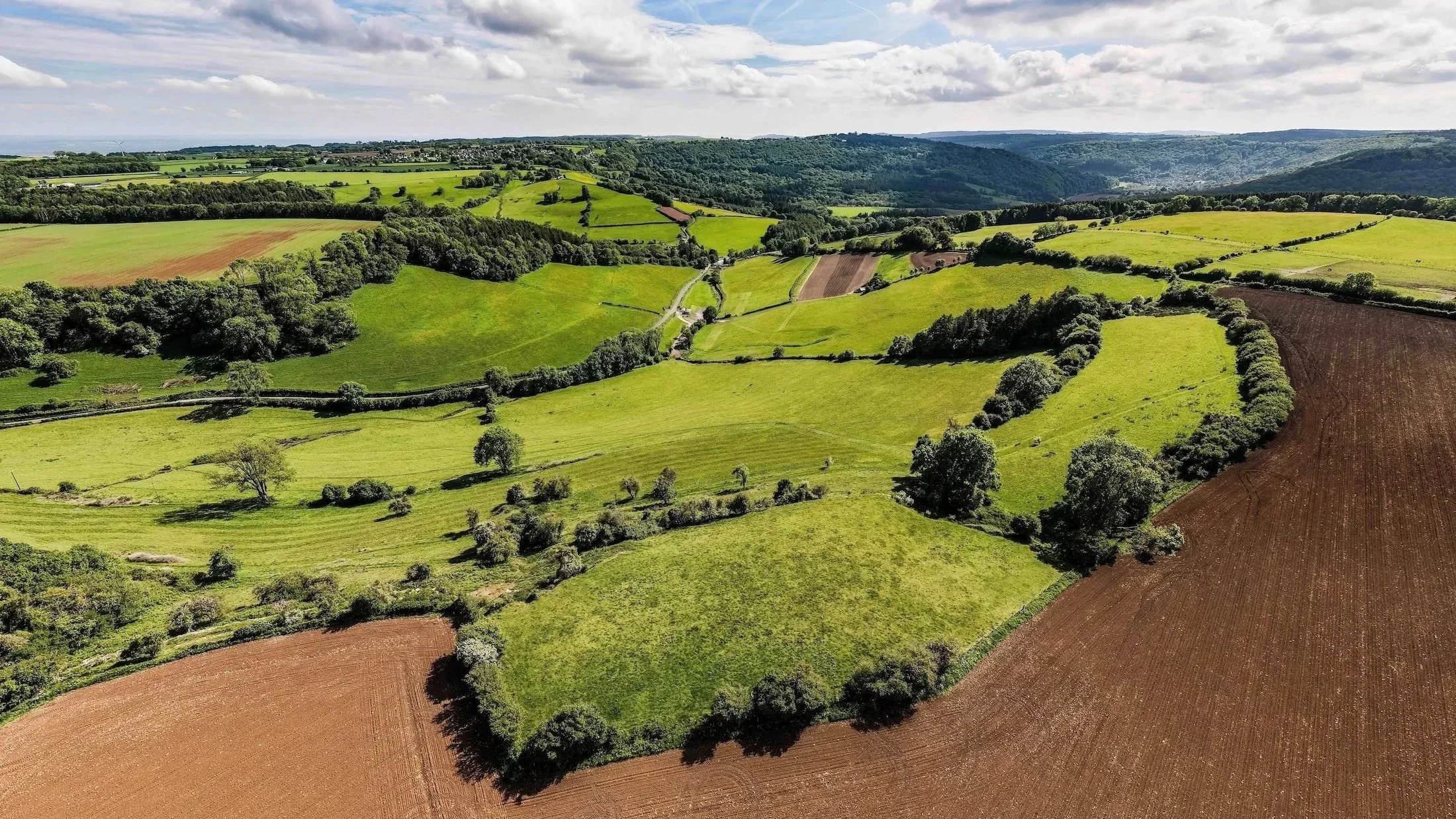 360° Panorama  Elevated aerial view across rolling fields, hedgerows, woodland and distant hills surrounding From Stone To Sky.