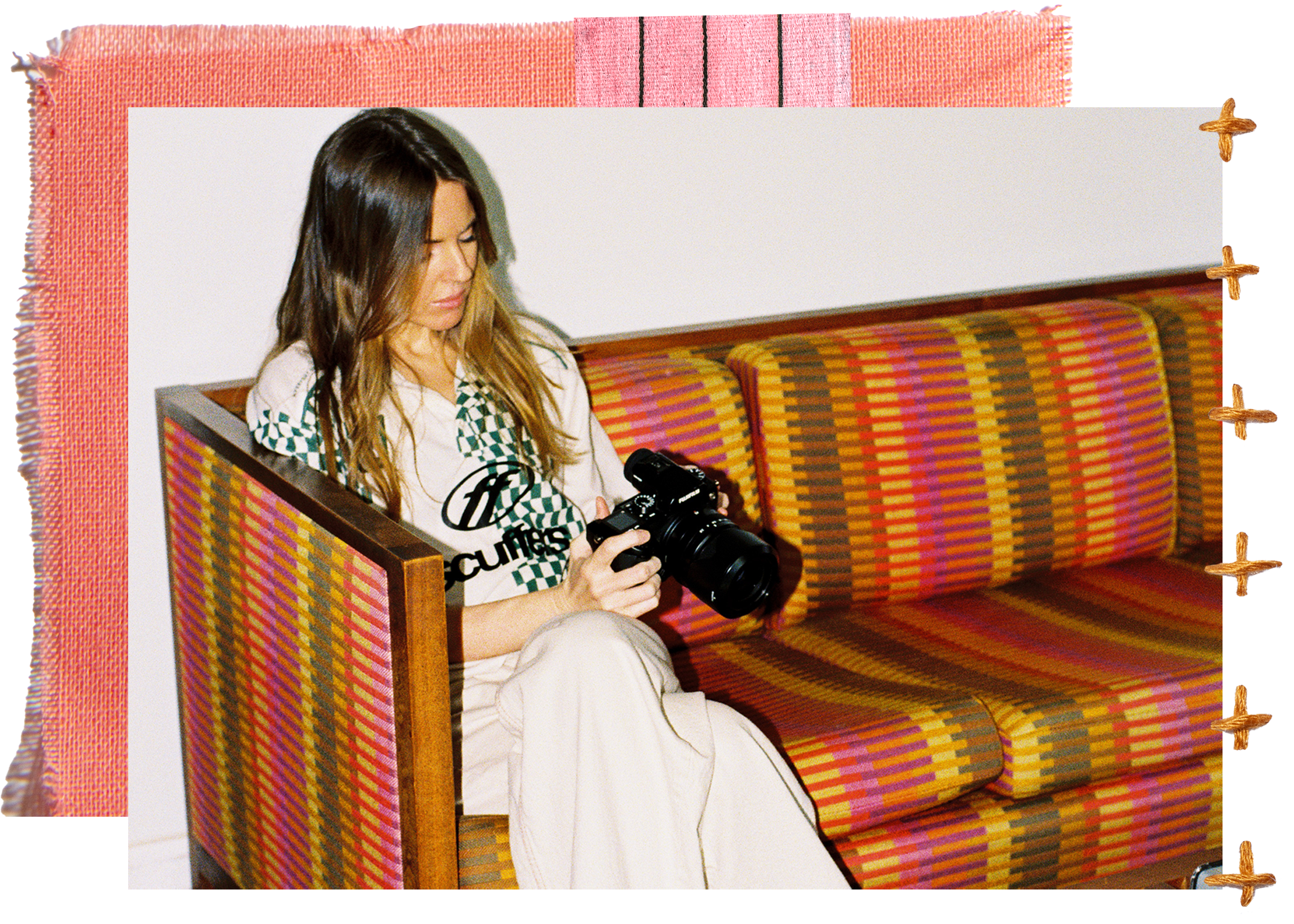 Molly Dickson holding a camera on a striped vintage sofa