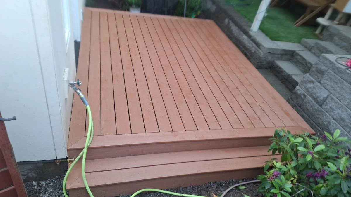 Wooden deck with a garden hose attached to an outdoor faucet.