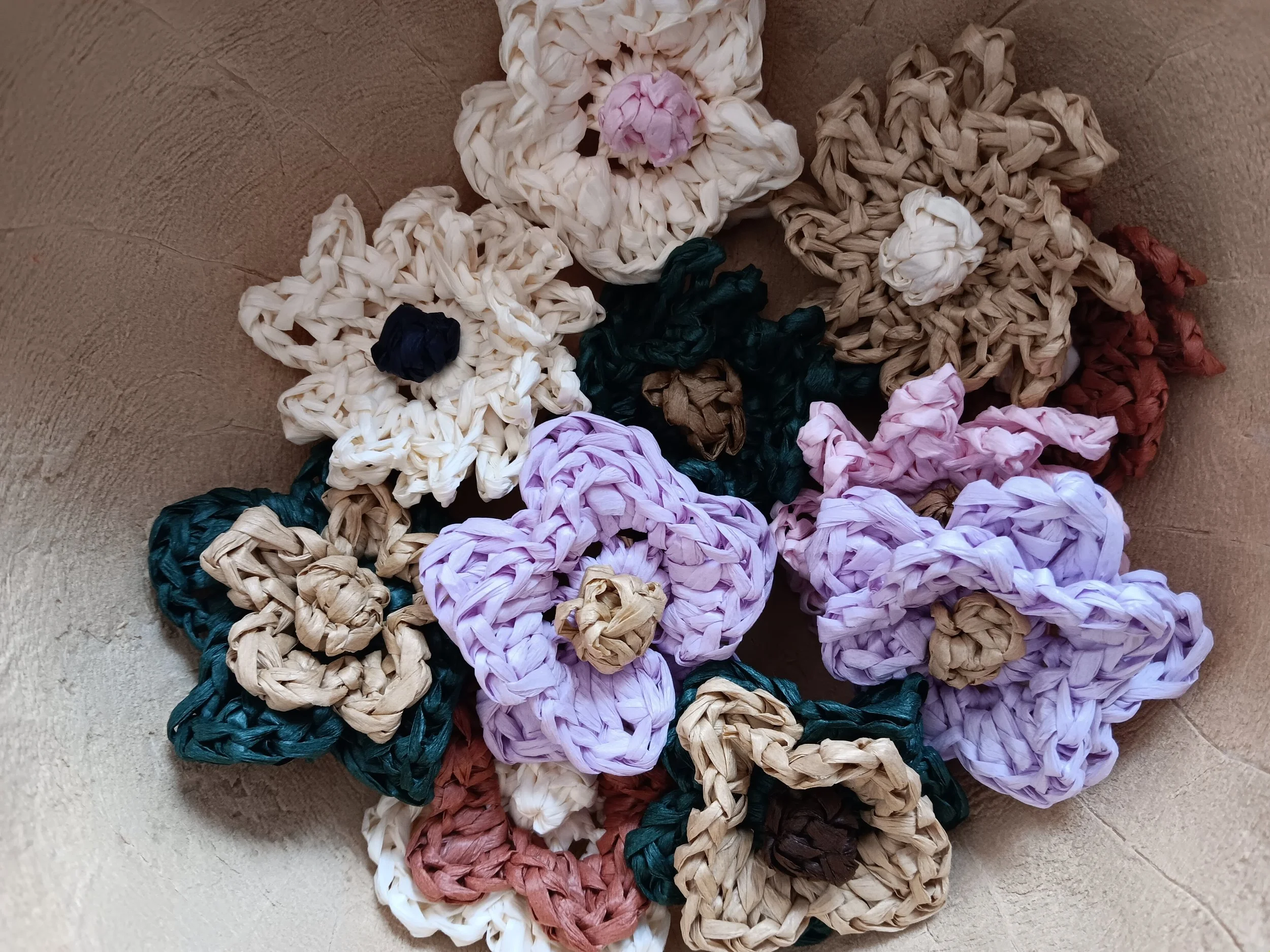 Close-up of woven rubber bands arranged in the shape of a Minnie Mouse head, with pink and purple bows, placed on a textured surface.