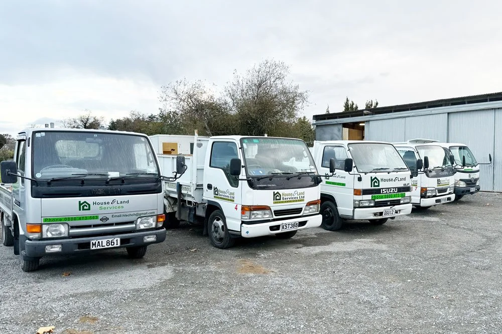 Five white service trucks from house and land services christchurch