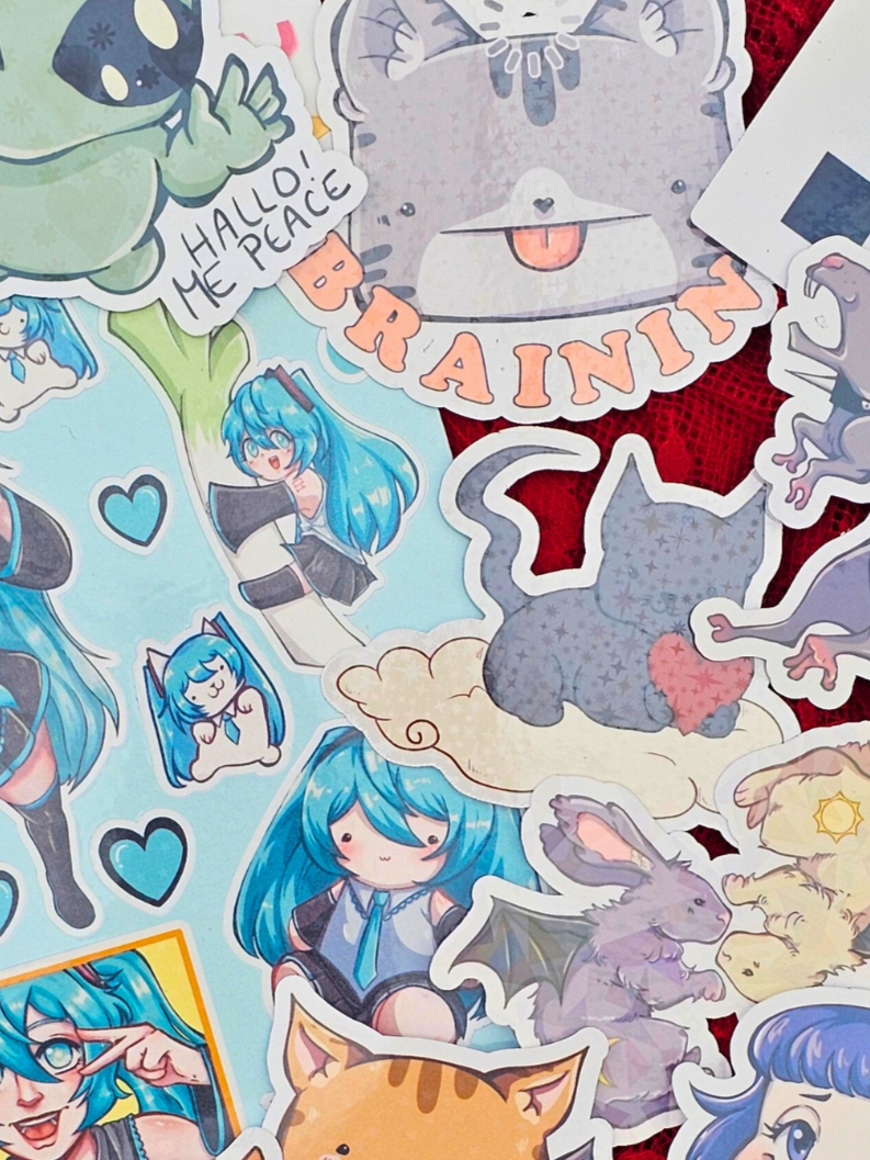Collection of colorful anime-style stickers featuring characters with blue hair, animals like a cat and rabbit, and various whimsical designs and text.