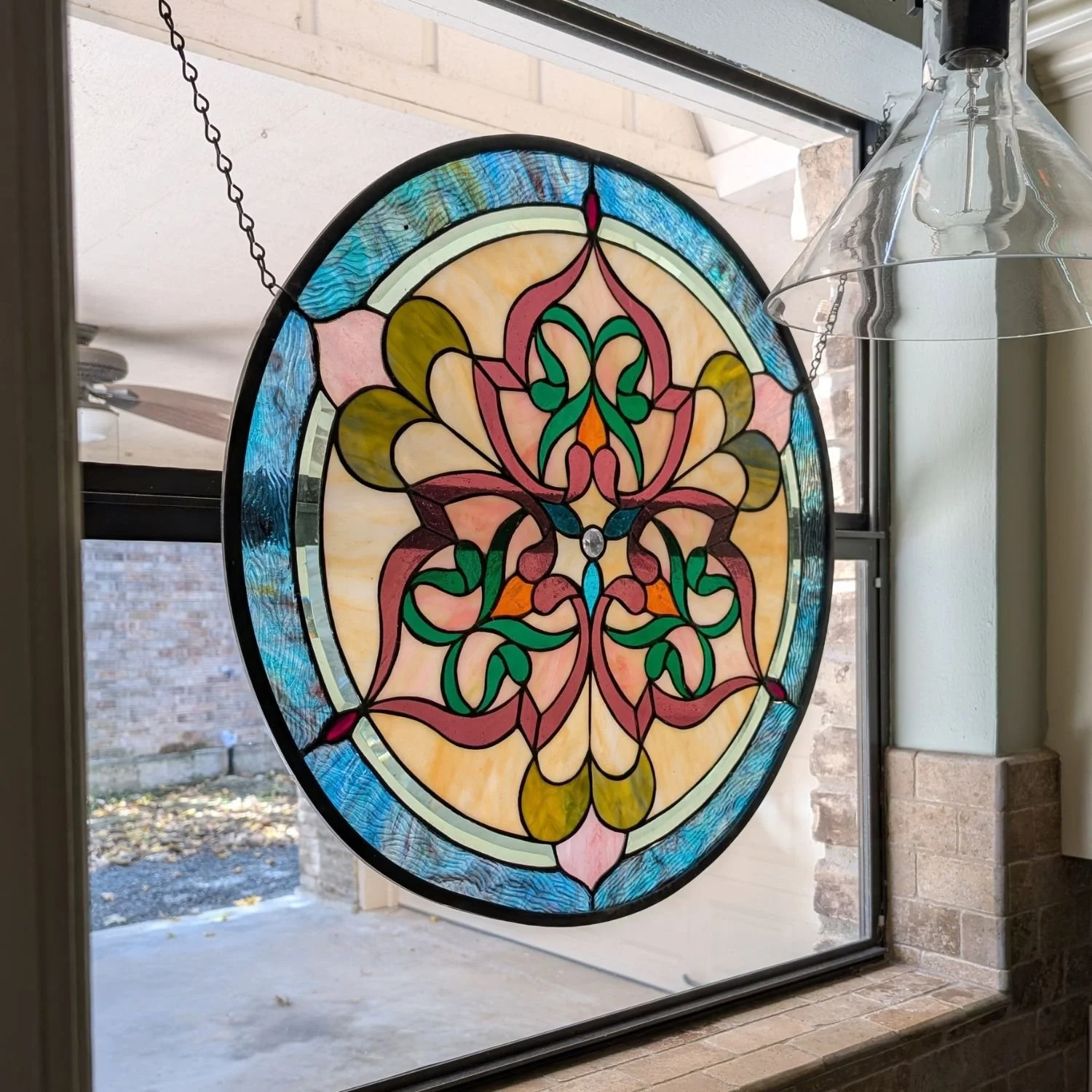 Stained glass window with vibrant orange, turquoise, and purple glass