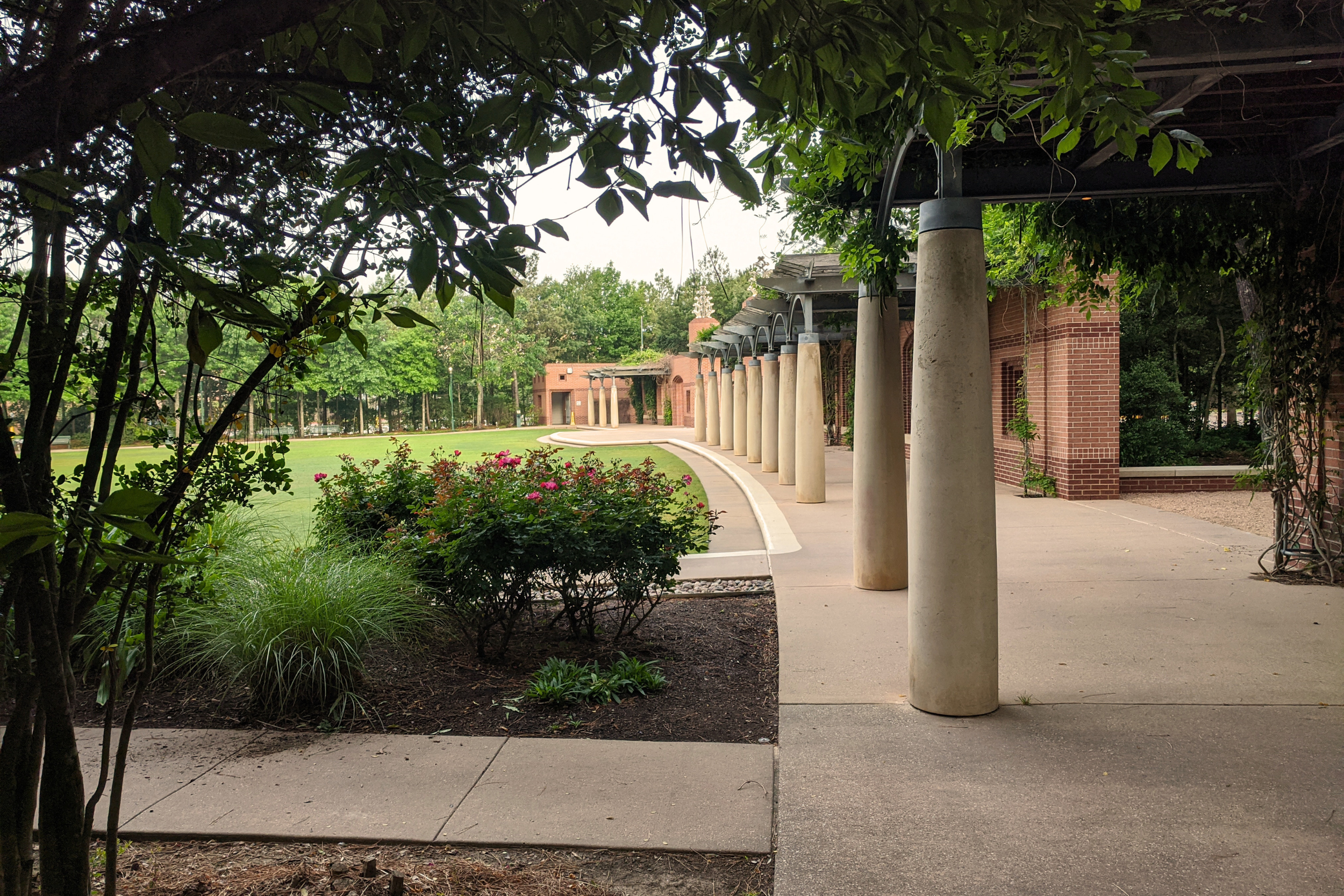 Covered walkway with columns beside a landscaped courtyard