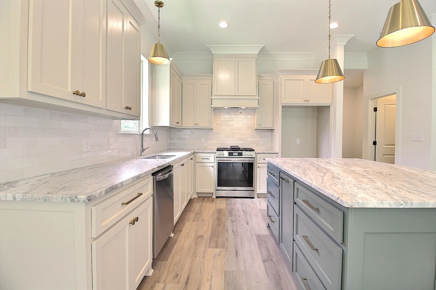 Bright custom kitchen with white cabinetry and a gray-green island in the Burlington Lakes home