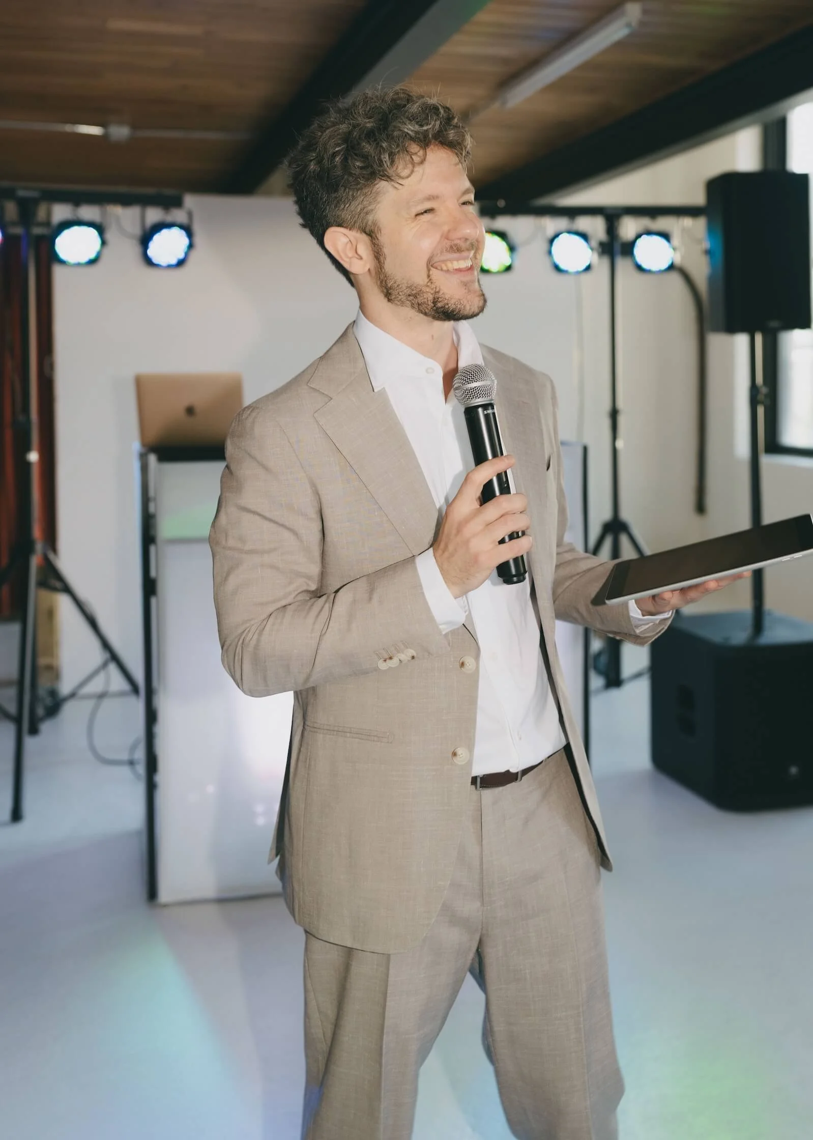 Jimmy in tan suit with microphone emceeing