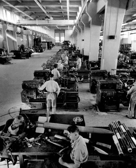 Black and white photo of the China lake machine shop with workers operating machinery, possibly from the mid-20th century.