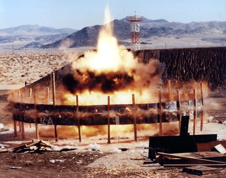 Explosion inside a circular reinforced structure in a desert landscape.