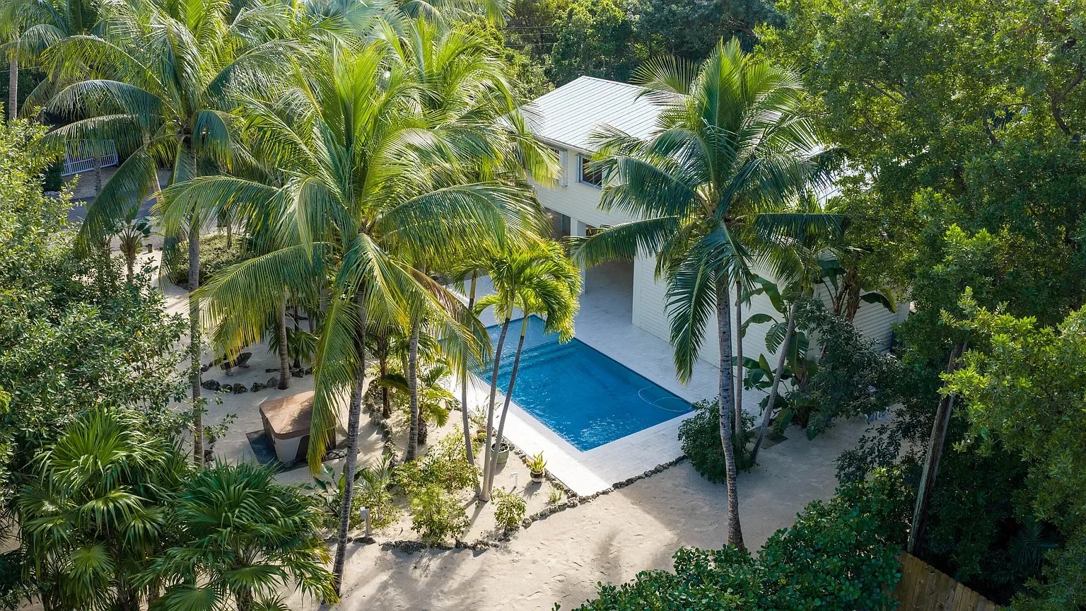 Private swimming pool and hot tub on Plantation Key, Florida Keys, surrounded by lush palm trees