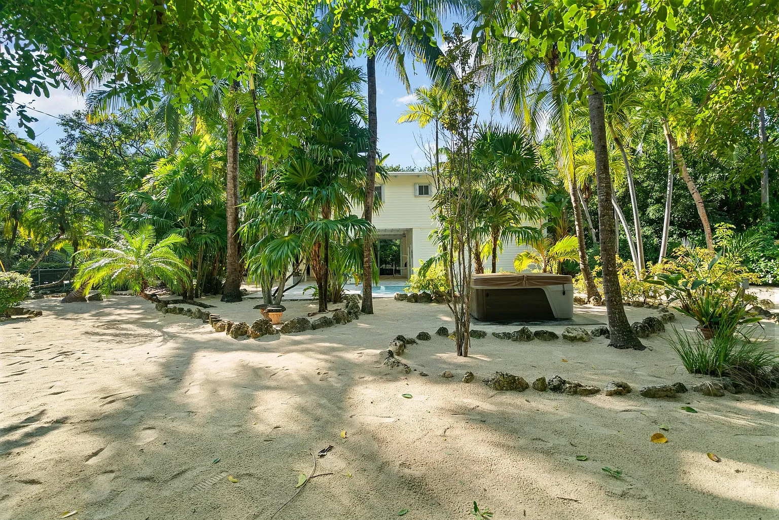 A tropical backyard with a 4 person hot tub.