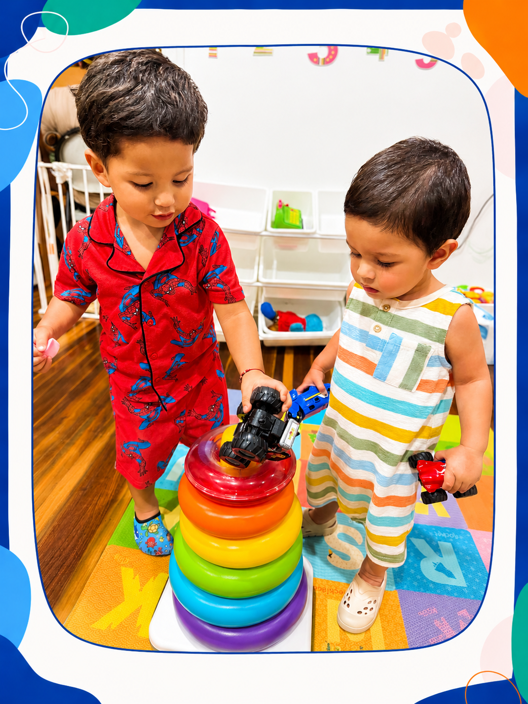 Two young boys playing with colorful toy stacking rings in a playroom.
