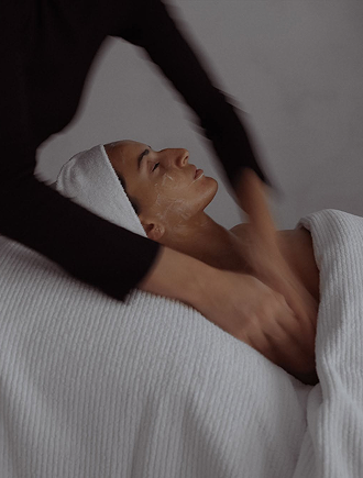 Person receiving a facial massage in a spa or wellness setting.