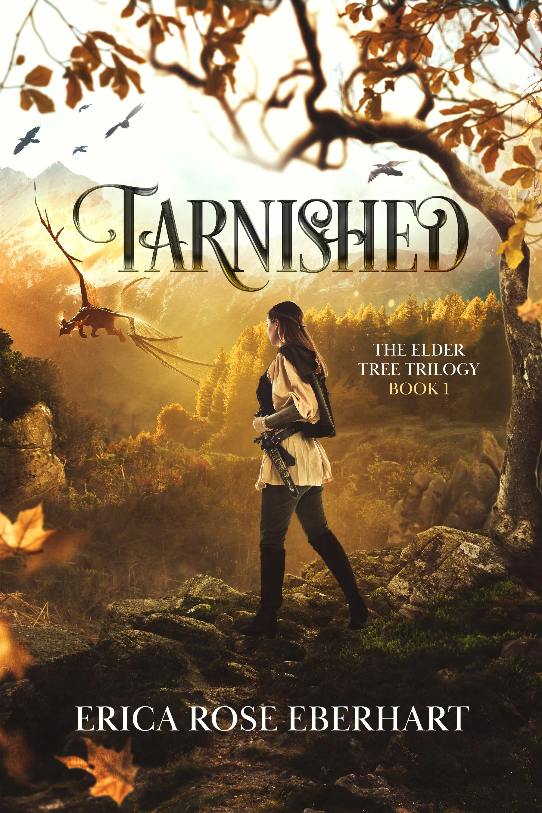 Book cover for "Tarnished: The Elder Tree Trilogy, Book 1" by Erica Rose Eberhart. Features a woman with a rifle standing on rocky terrain surrounded by autumn trees and mountains, with flying birds and a dragon flying in the sky, all bathed in warm, golden sunlight.