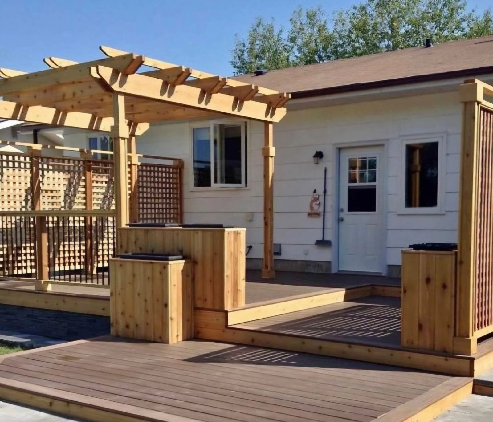 Wooden backyard deck and pergola under construction, creating a stylish and functional outdoor space that blends seamlessly with the home and surrounding landscape.
