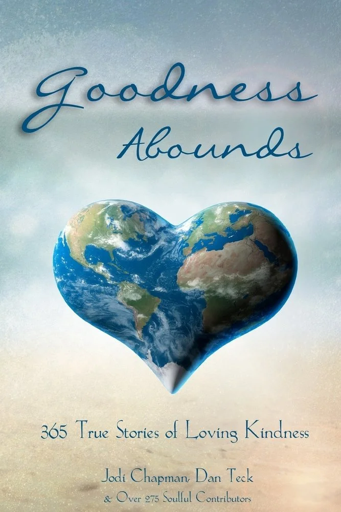 Book cover titled 'Goodness Abounds' featuring a heart-shaped Earth and subtitle '365 True Stories of Loving Kindness,' authored by Jodi Chapman, Dan Teck, and over 275 contributors.