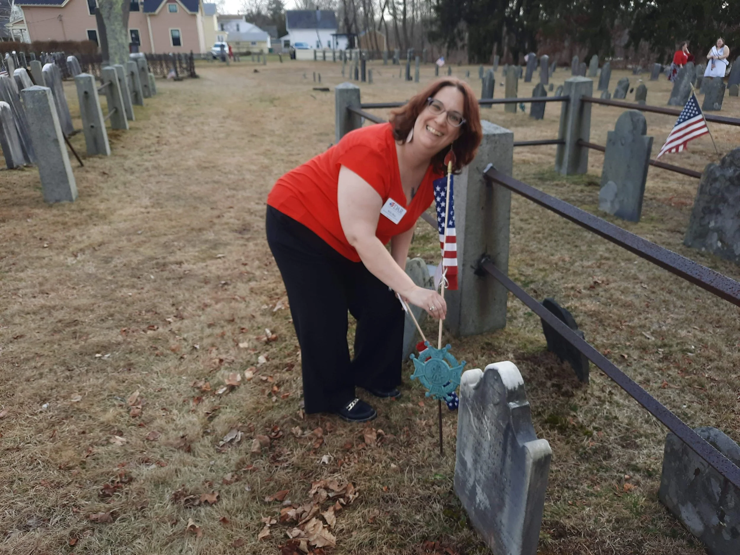 Participating in a DAR flag placement ceremony honoring veterans and preserving the memory of those who served.