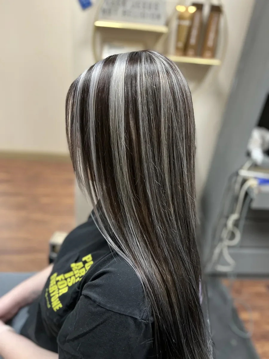Black hair with silver face-framing highlights by The Hair Court in Bryan-College Station, TX.