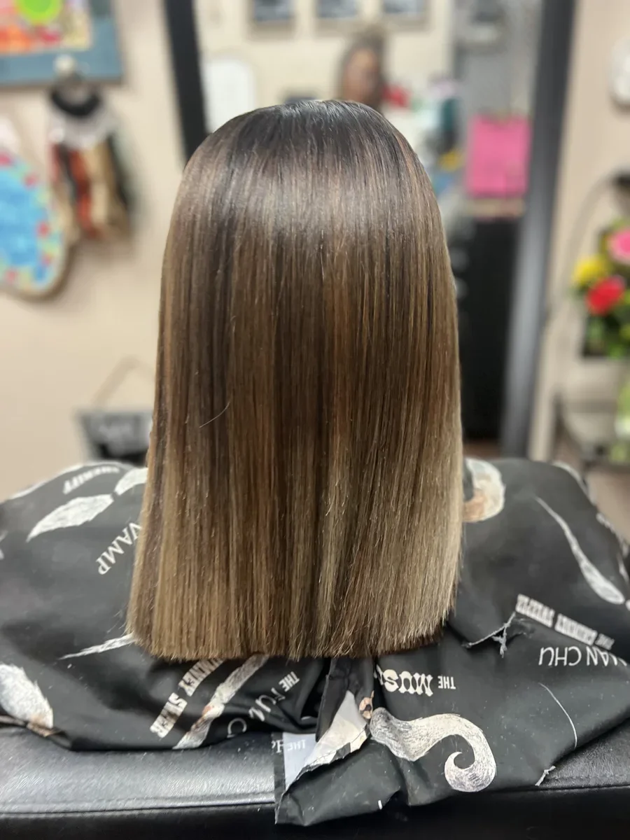 Long glossy brunette straight hair by The Hair Court in Bryan-College Station, TX.