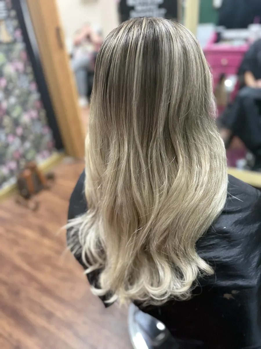 Long silver blonde wavy hair by The Hair Court in Bryan-College Station, TX.