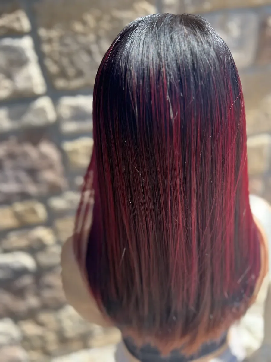 Dark hair with red-violet ends by The Hair Court in Bryan-College Station, TX.