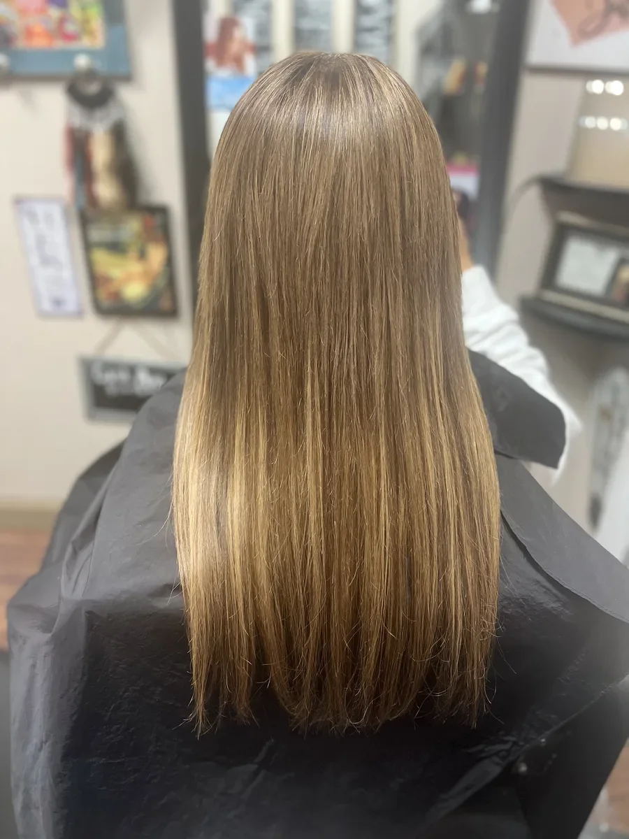 Long warm blonde straight hair by The Hair Court in Bryan-College Station, TX.