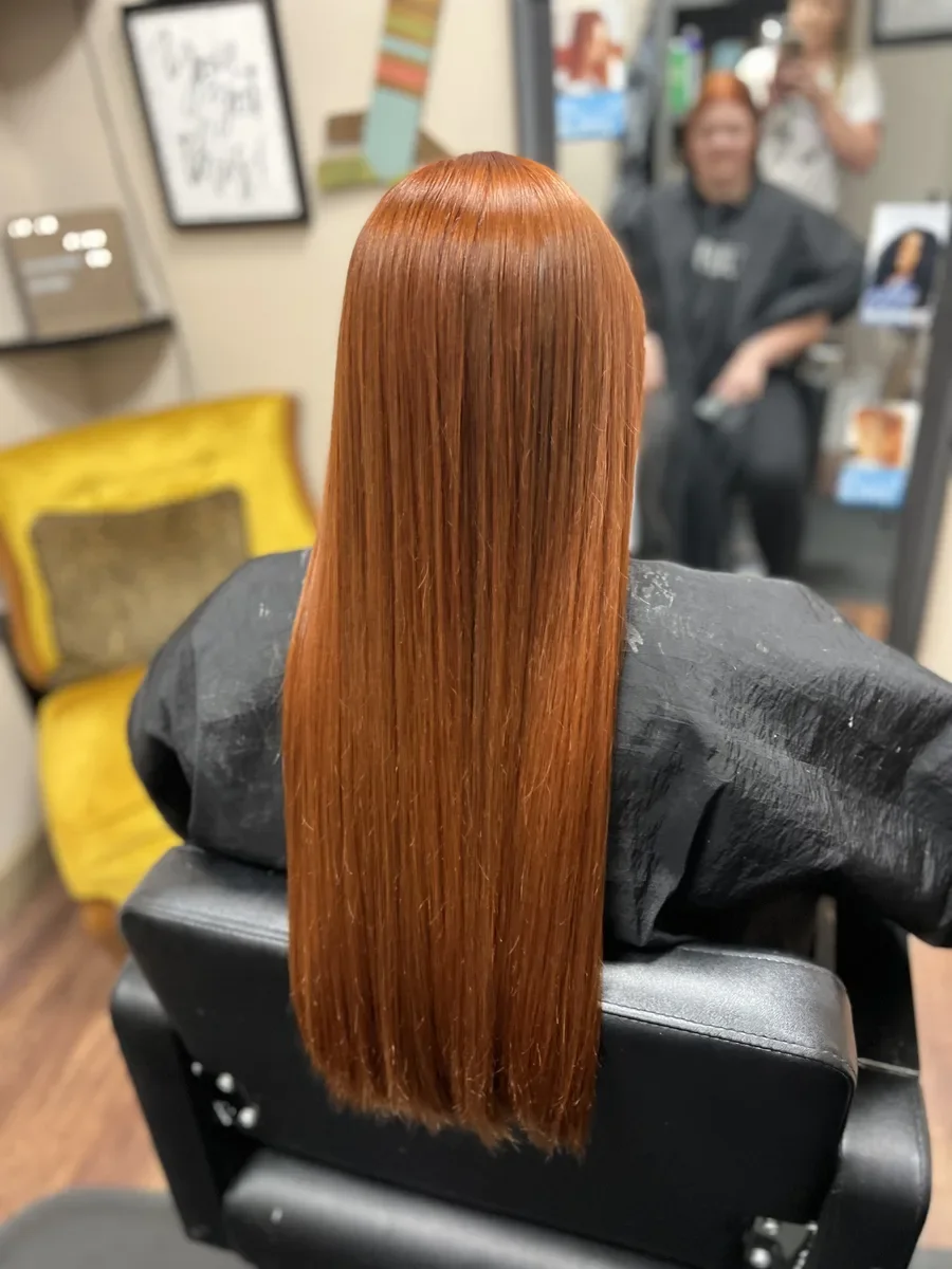 Long copper straight hair by The Hair Court in Bryan-College Station, TX.