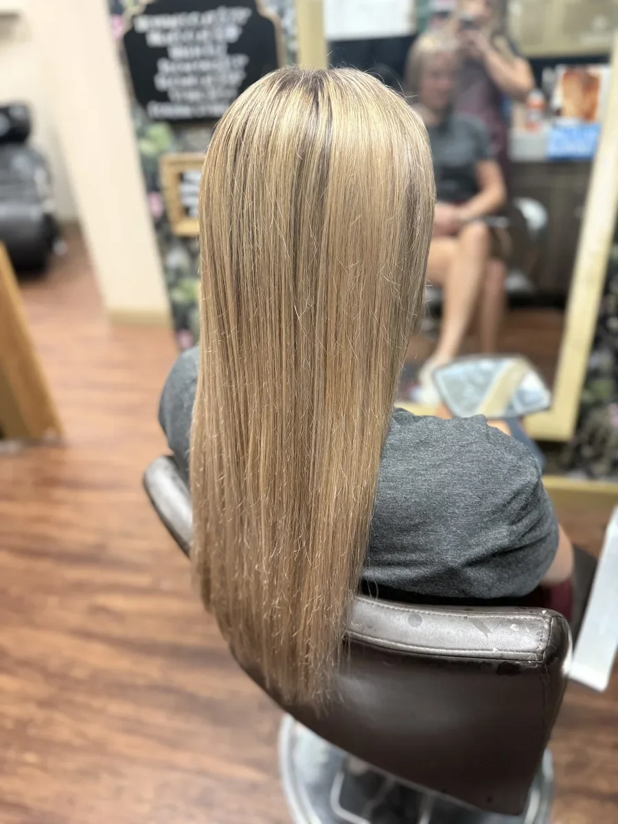 Long dimensional blonde straight hair by The Hair Court in Bryan-College Station, TX.