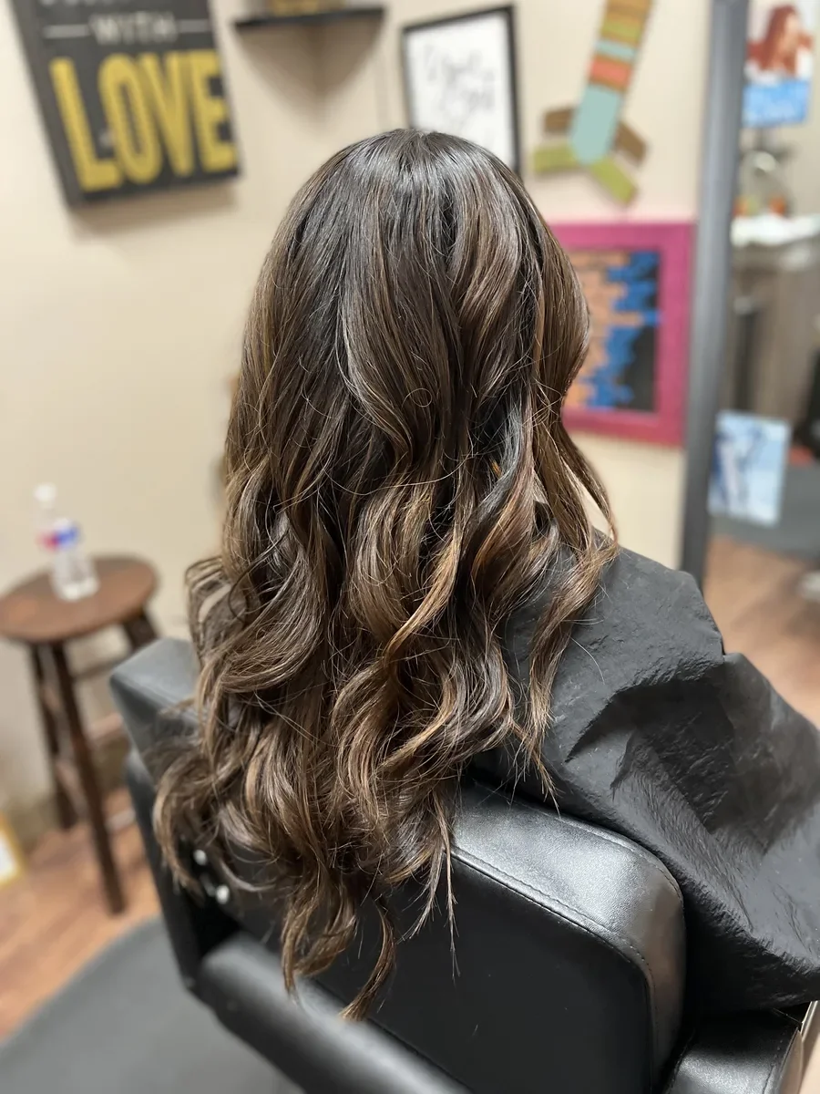 Long brunette wavy hair by The Hair Court in Bryan-College Station, TX.