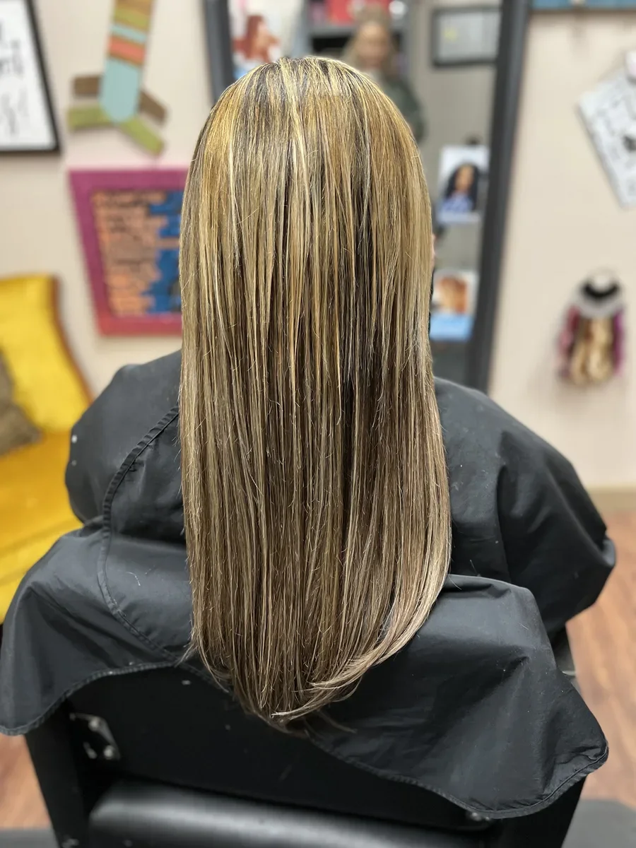 Long dimensional blonde straight hair by The Hair Court in Bryan-College Station, TX.